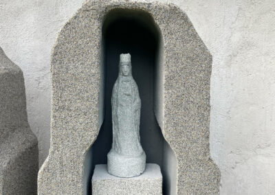 Gedenkstein für die Verstorbenen in Form eines Marterl/Grotte mit Statue und Drehtisch